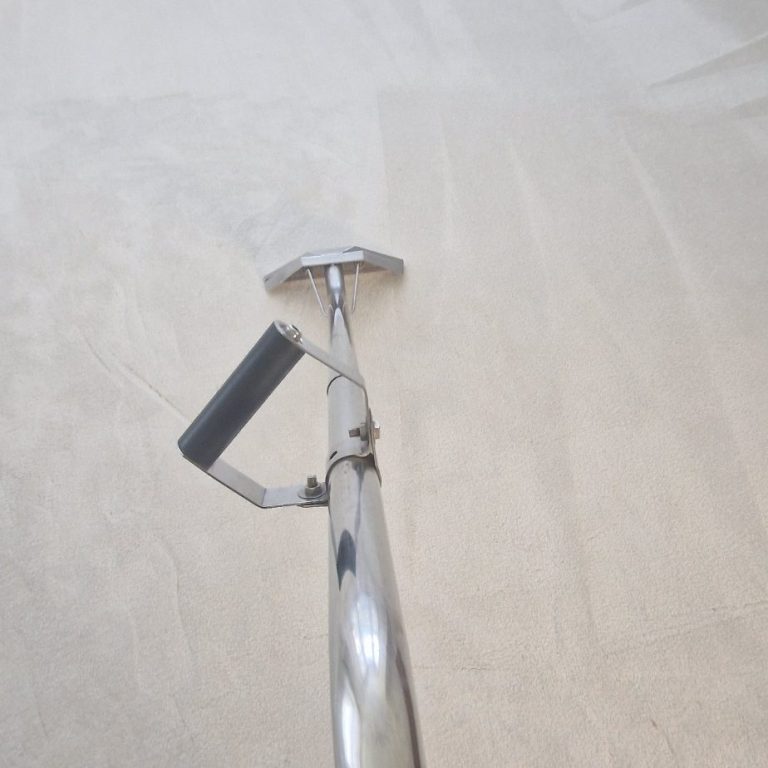 Carpet Cleaning A close-up of a chrome carpet cleaning tool on a light surface.