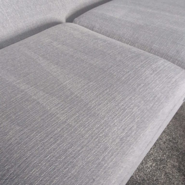 Sofa cleaning Close-up of a light grey fabric sofa cushion.